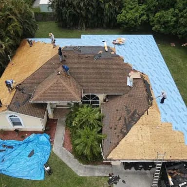 Drone view of a roof replacement in progress — old shingles being torn off and new underlayment going down.